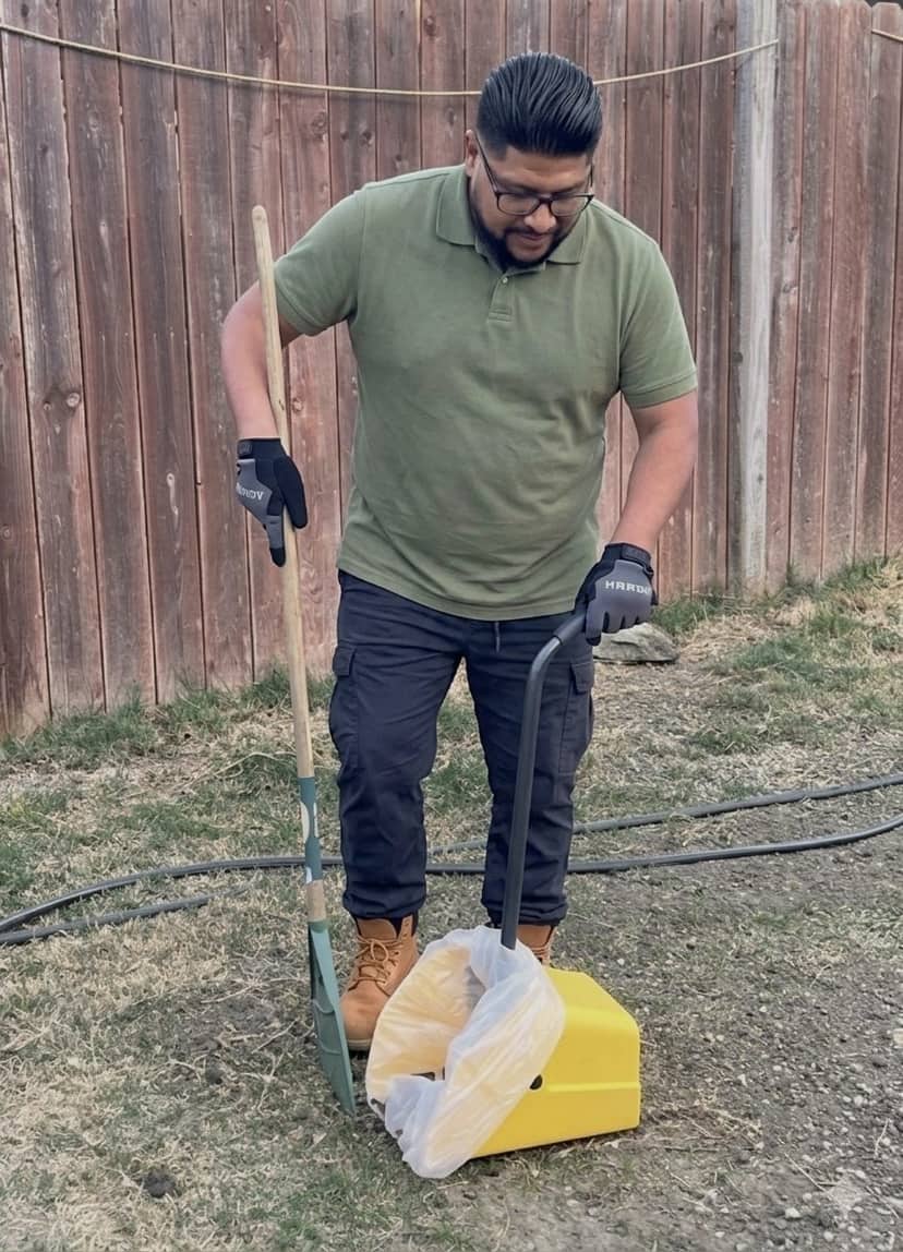 Josue, owner of Scoop Dogg, cleaning a backyard
